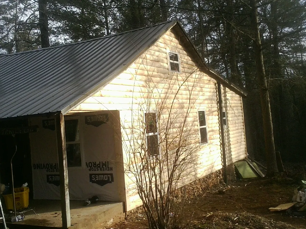 Log siding gable end under a dark metal roof edge in Lake Hopatcong