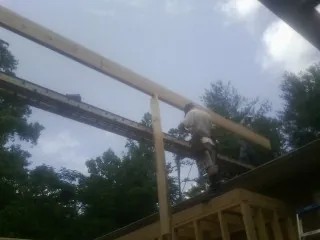 Carpenter setting a ridge beam over a new addition frame — Ice Dam Removal by Roofing Brothers in Lake Hopatcong