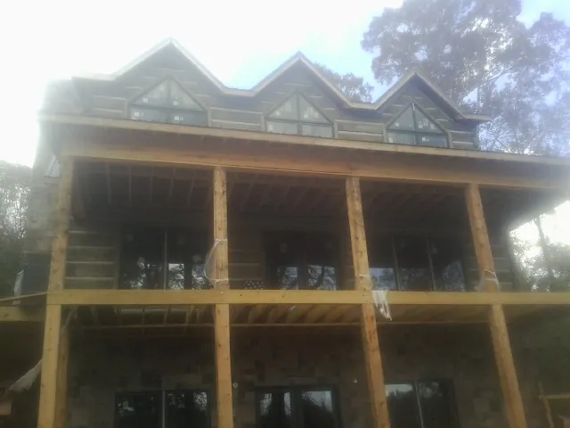 Dormers and porch framing on a large log home under construction — Roof Coating work by our crew in Lake Hopatcong
