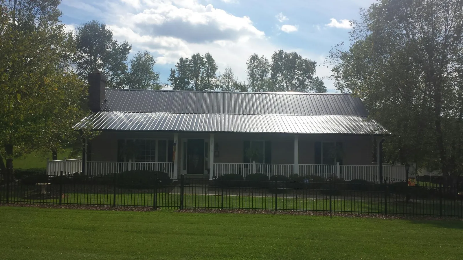 Gray metal roof on a brick ranch with a full width front porch — Gutter Guard Installation work by our crew in Lake Hopatcong