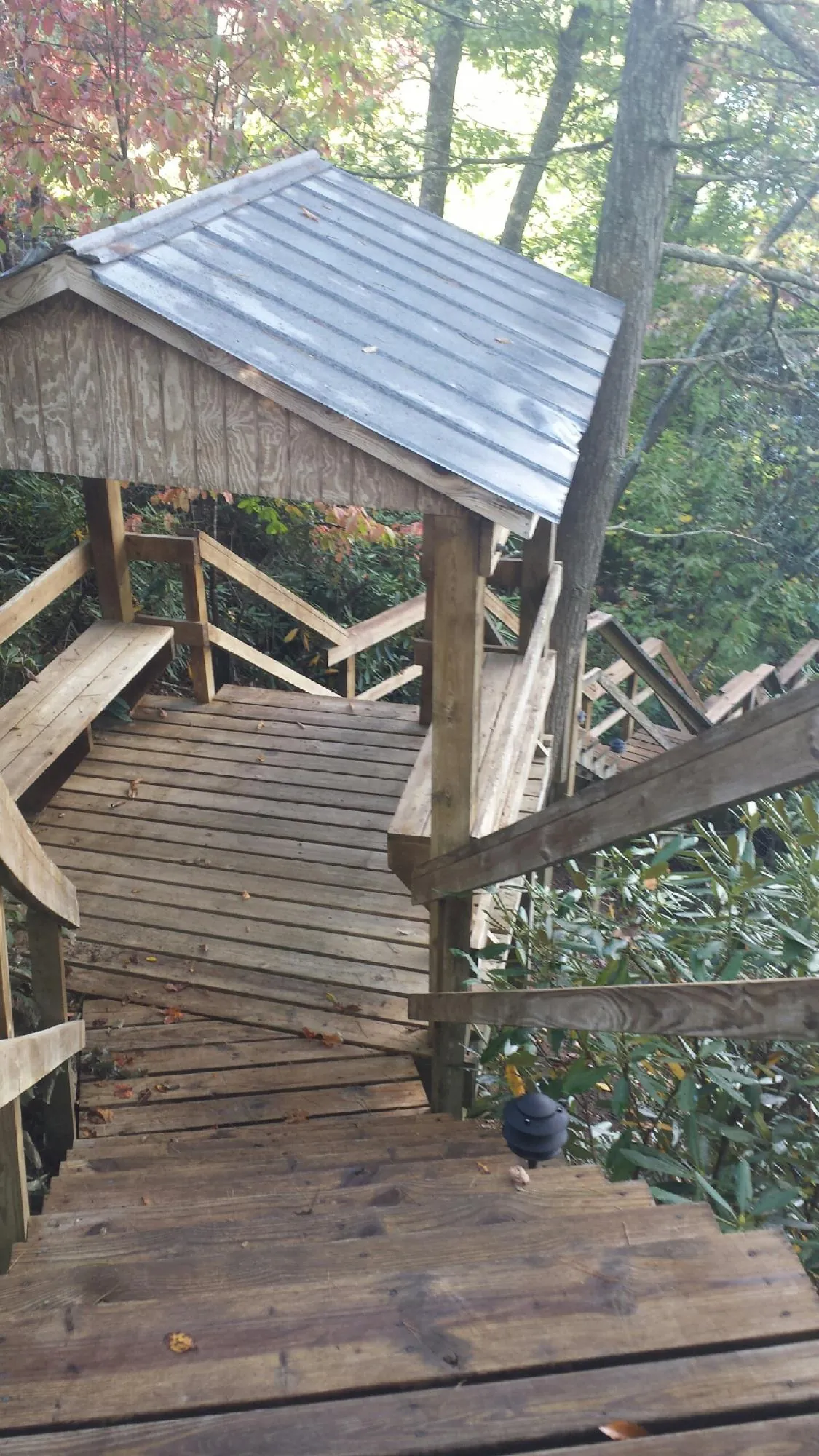 Metal roofed shelter over wooden steps on a wooded walkway — Skylight Repair & Installation work by our crew in Lake Hopatcong