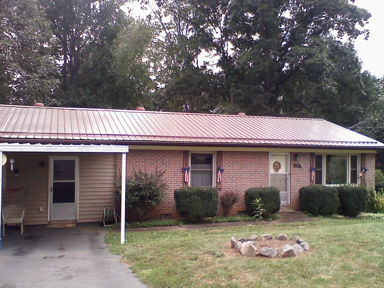 Bronze metal roof and carport on a brick ranch home — Roof Repair work by our crew in Lake Hopatcong